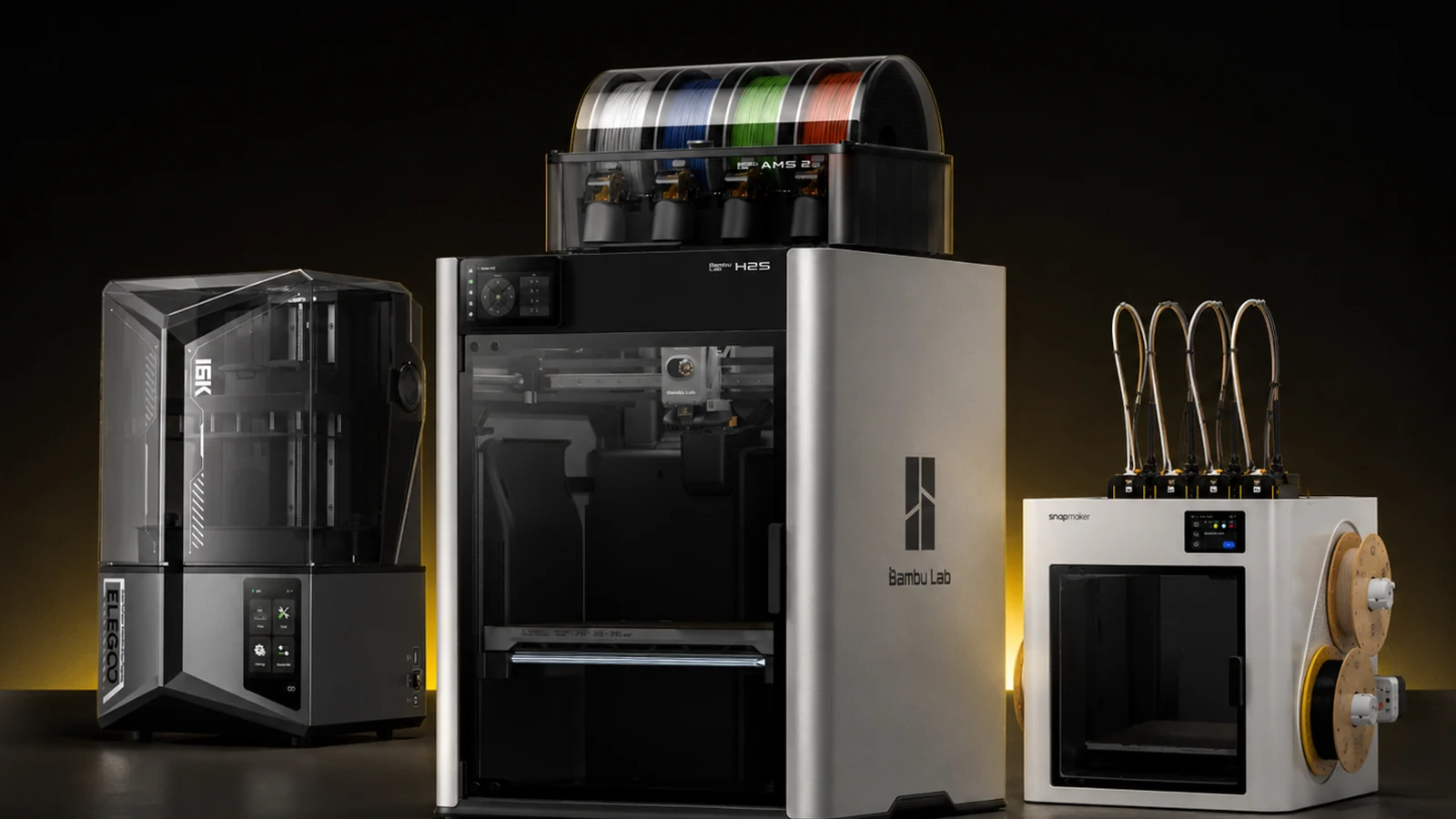 Three printers in the workshop: a resin printer, one with a multi-colour feeder, and one with filament spools